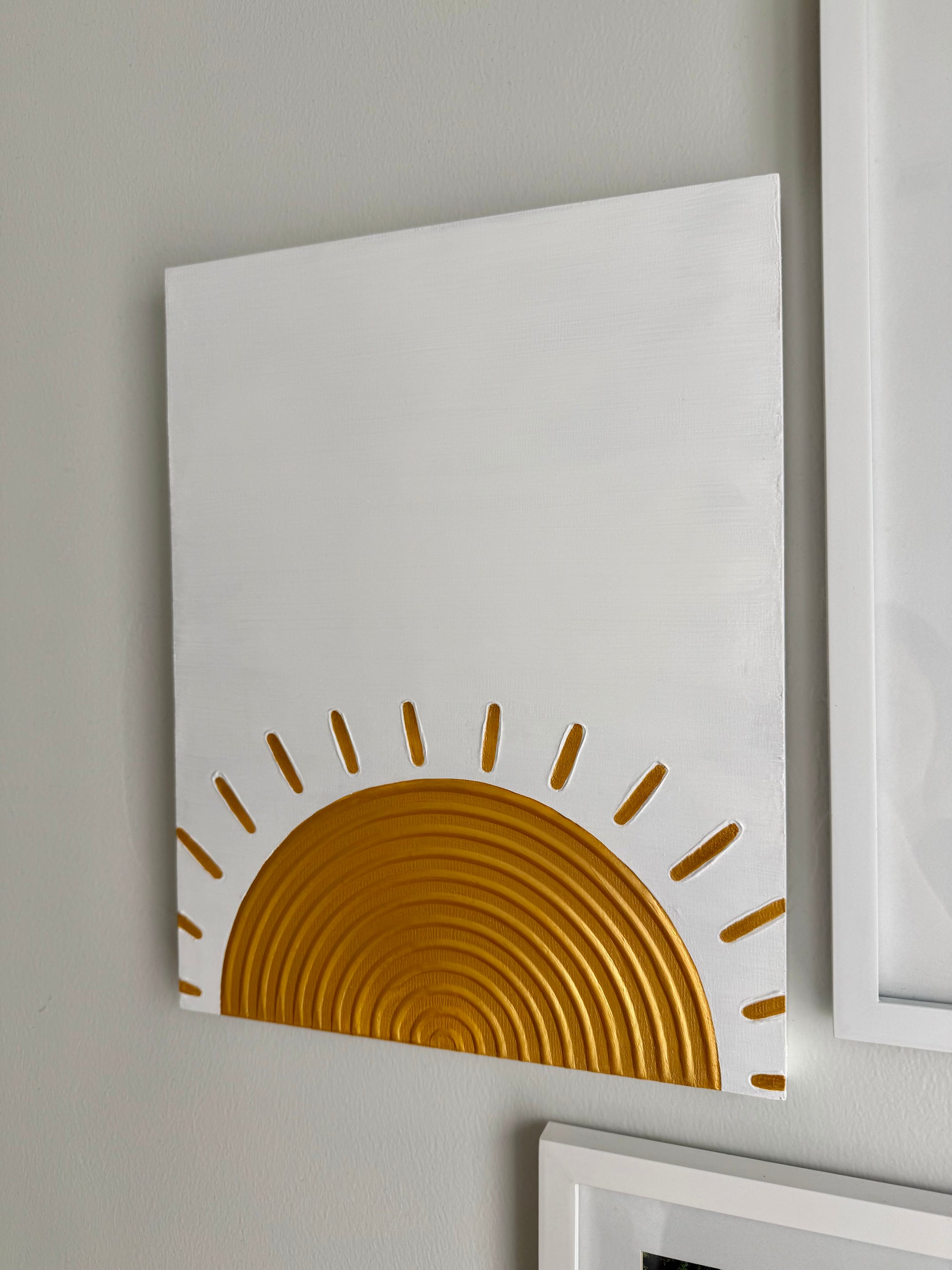 White wall with a gold sun-shaped decorative piece