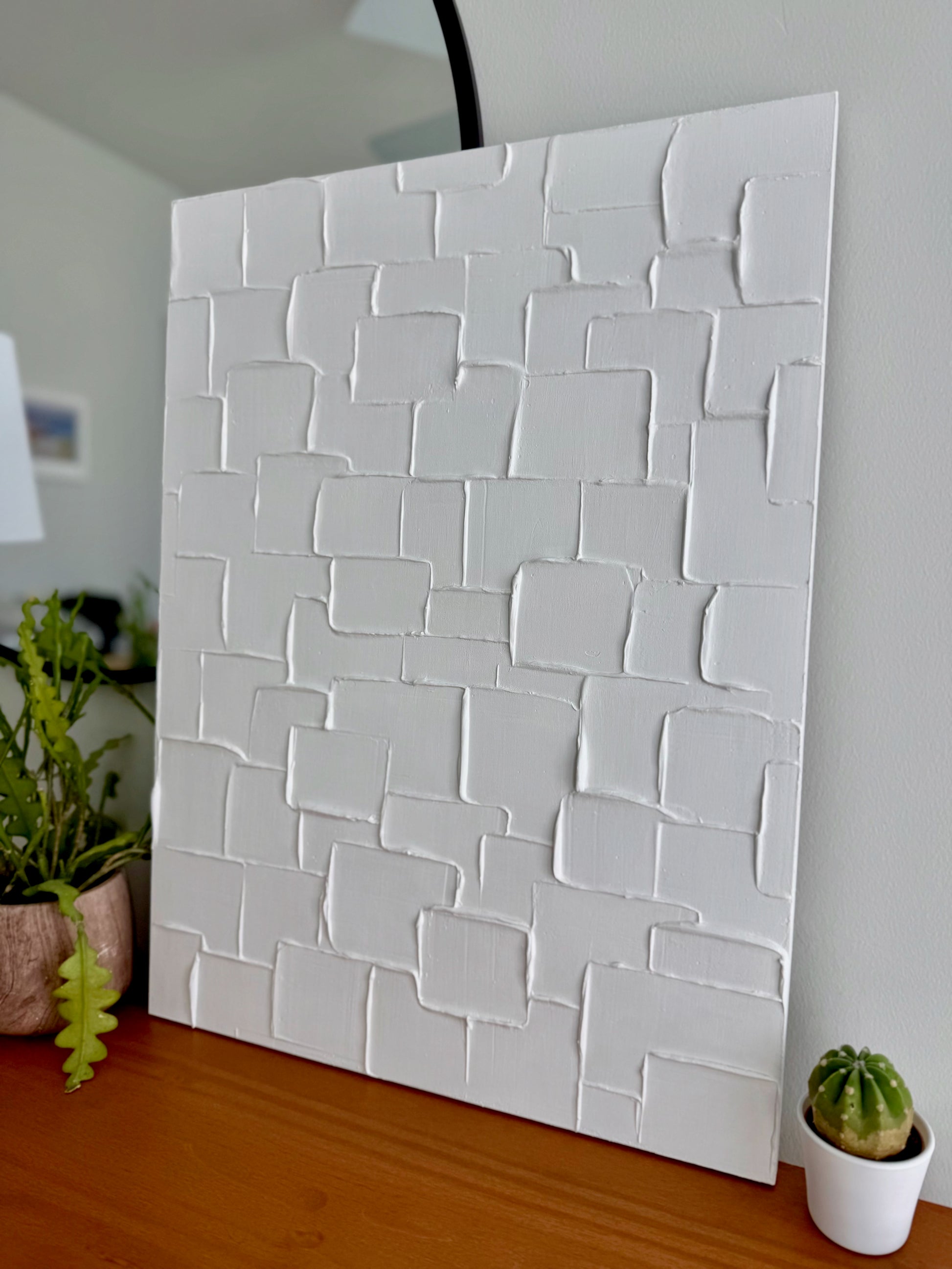 White textured wall panel in a room with plants