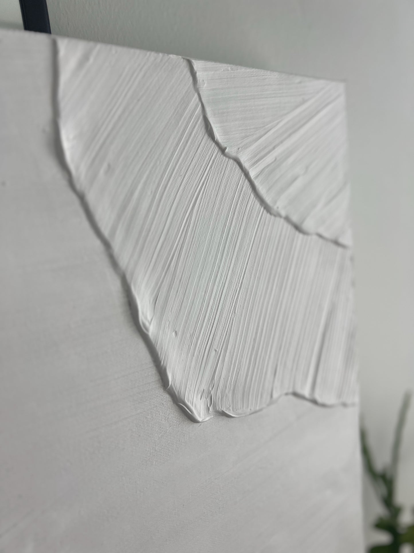 Close-up of a textured white artwork on a light gray background