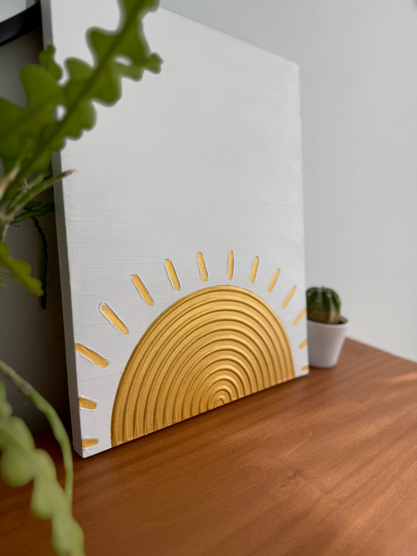 Decorative wall art with a sun design on a wooden surface.